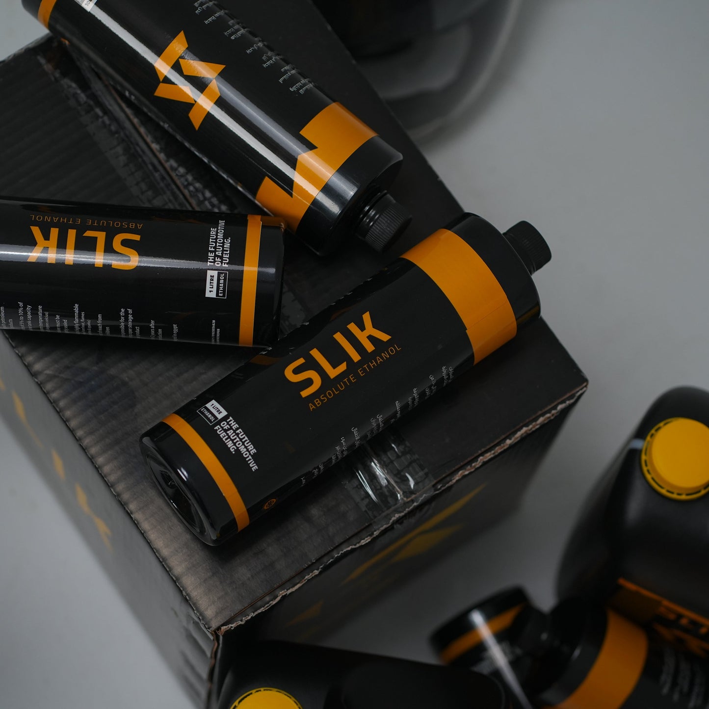 Slik hair product bottles with packaging on a gray surface