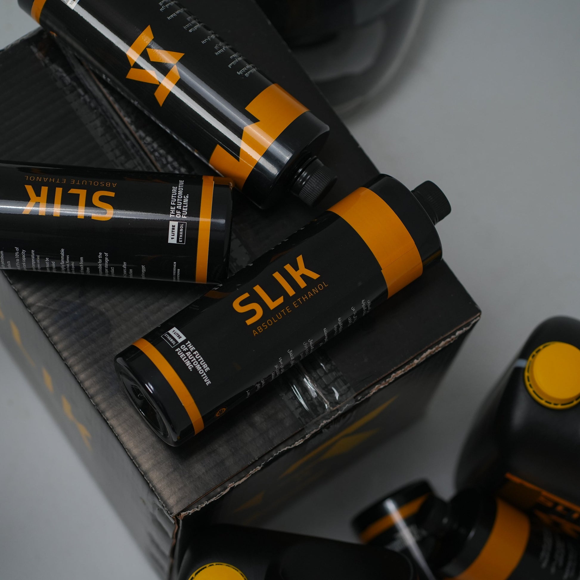 Slik hair product bottles with packaging on a gray surface